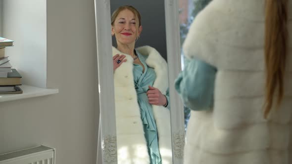 Reflection in Mirror of Elegant Stylish Middle Aged Woman Smiling Trying on New Luxurious Dress