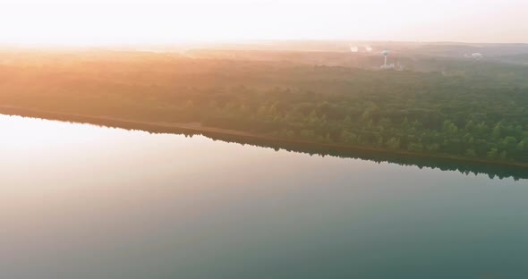 Mist Blankets the Forest Lake During a Foggy Sunrise