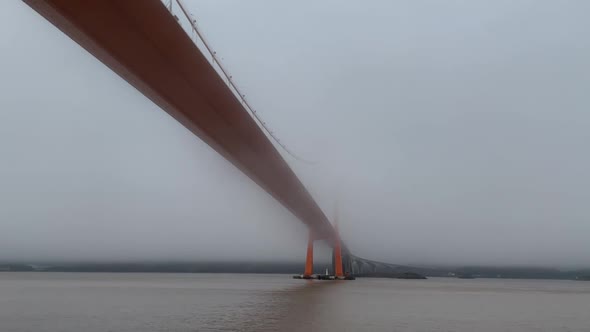 bridge cross the sea in fog from the sight of boat.