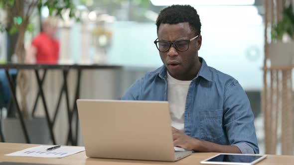 Young African Man Reacting to Loss While Using Laptop