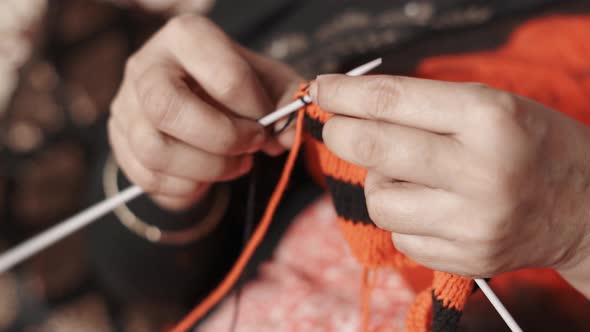 Close up of woman's hands knitting a new row with black wool. 4k footage of knit work tie-up hand wo