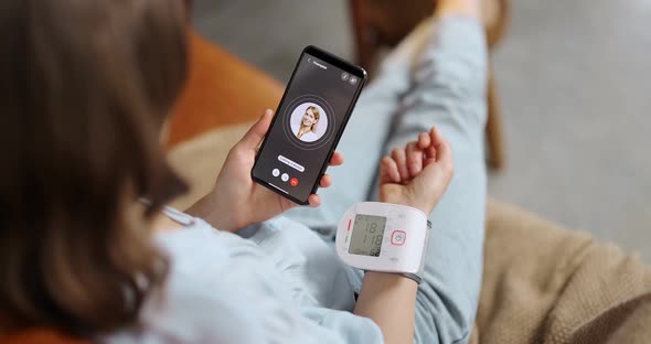 Woman Measures Blood Pressure Calling a Doctor