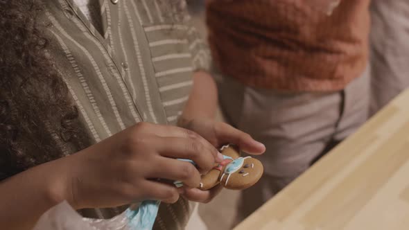 Close Up of Girl Decorating Gingerbread Cookie