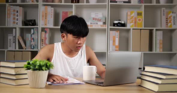 Tired man using laptop and looking document