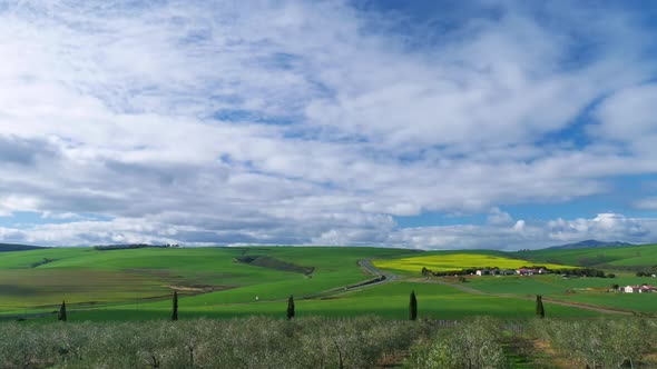 TimeLapse - Cloudsing over green hills of countryside, shot from vantage point over olive grove