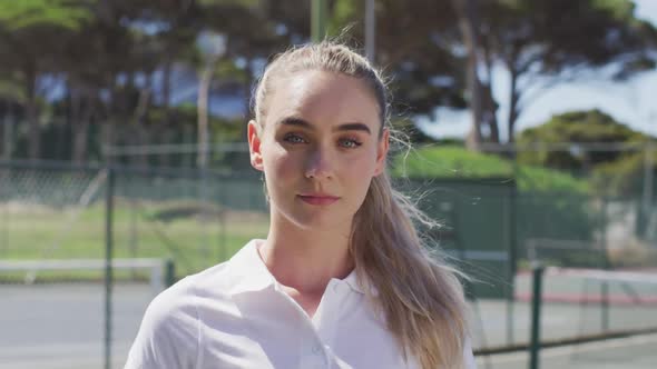 Video of caucasian female tennis player holding racket and looking at camera