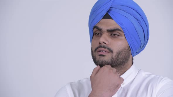 Face of Happy Young Bearded Indian Sikh Man Thinking