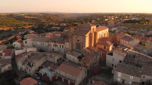 Aerial footage of flying around an 11th century old french provence church during sunset in Valensol