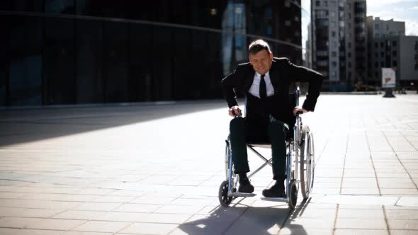 Cripple Businessman Trying To Get Up From Wheelchair Outdoor