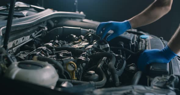 Close Up of Mechanic Examining Engine of Damaged Vehicle at Repair Station, Tracking Shot