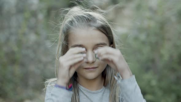 Medium Shot of Caucasian Girl Putting Stones to Her Eyes