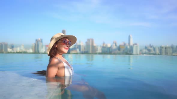 Young asian woman enjoy around outdoor swimming pool for leisure