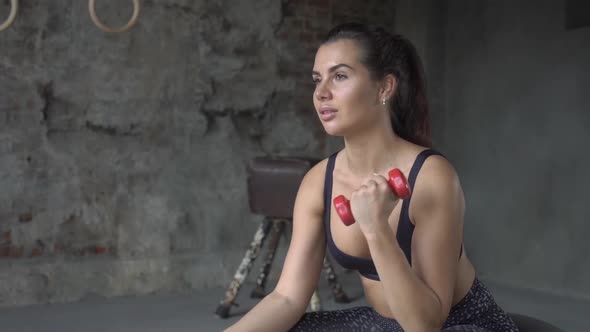 Young Sporty Girl Doing Exercise with Dumbbells