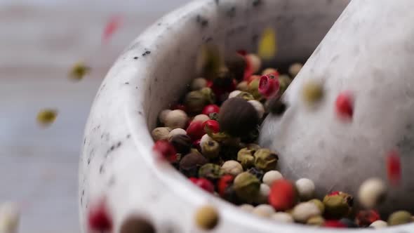 Pestle Falling Into Mortar with Peppercorn