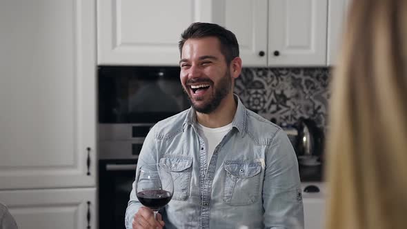 Handsome Young Man with Well-Groomed Beard Sincerely Laughing, Sitting