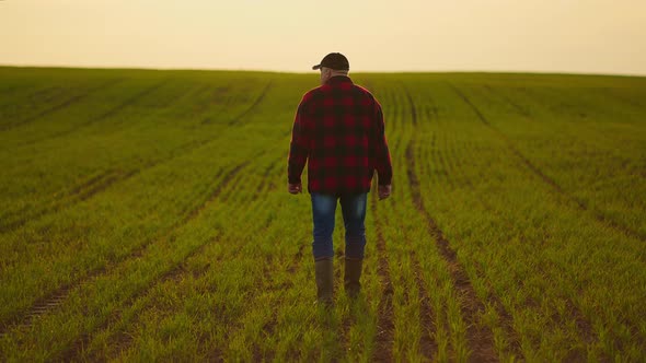 Portrait of a Tractor Farmer Walking Through a Field at Sunset After a Slowmotion Shoot