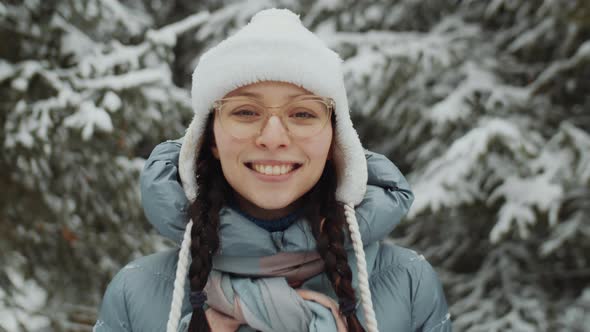 Portrait of Cheerful Woman in Forest on Winter Day