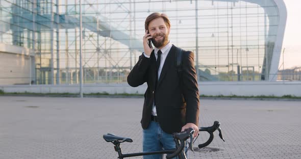 Guy in Formal Clothes which Standing Near His Bike and Enjoying Phone