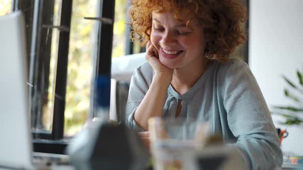 Young woman using smartphone and laptop in office