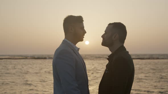 Gay couple together on the beach during sunset