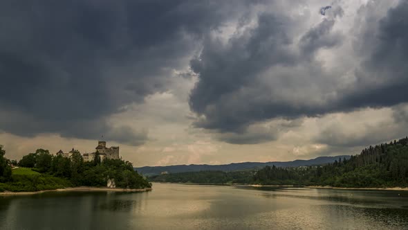 Clouds over Niedzica castle by lake in summer, Poland, Timelapse