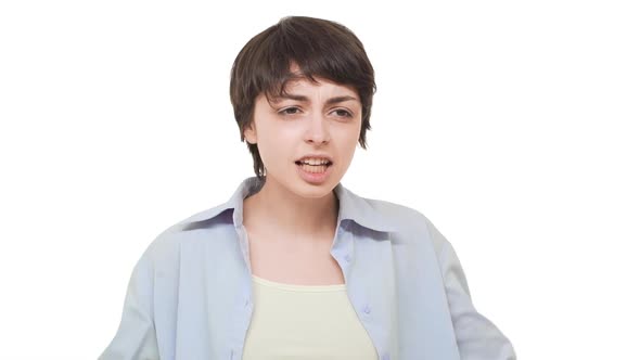 Annoyed Young Caucasian Girl with Short Haircut Arguing with Boyfriend Over White Background in