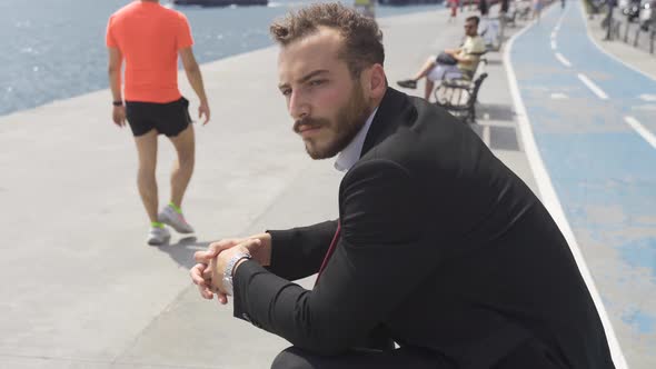 Businessman in suit sitting thoughtfully in the city.