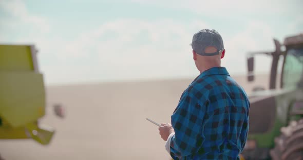 Farmer Using Digital Tablet While Examining Field