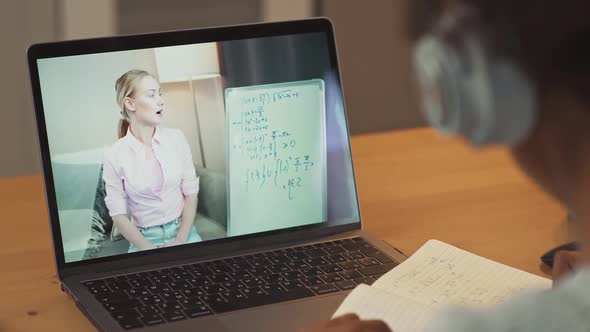 African Girl Sits at a Desk and Study Online Using a Laptop a Schoolgirl Learns in a Remote Lesson