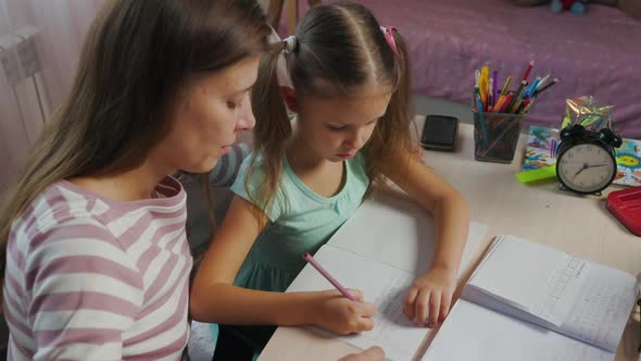 Mother And Daughter Doing Homework From School Together