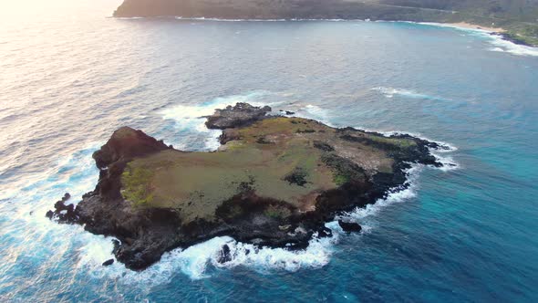 Drone tilting down over a mini private island in hawaii with oahu in the background