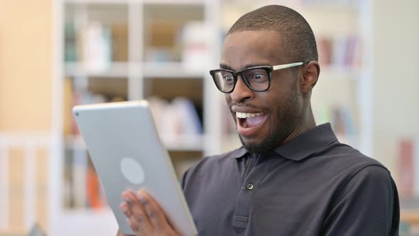 Portrait of Young African Man Celebrating on Tablet