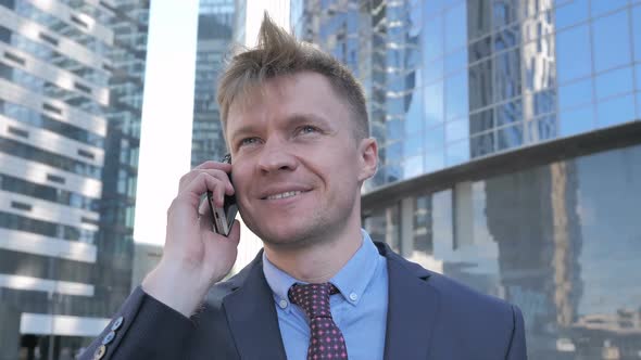 Businessman Talking on Phone Outside Office