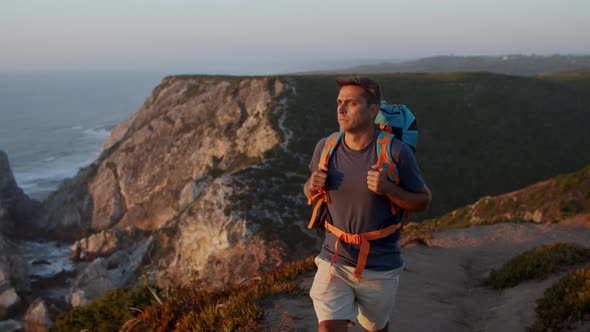 Active Male Tourist Walking Along Cliff