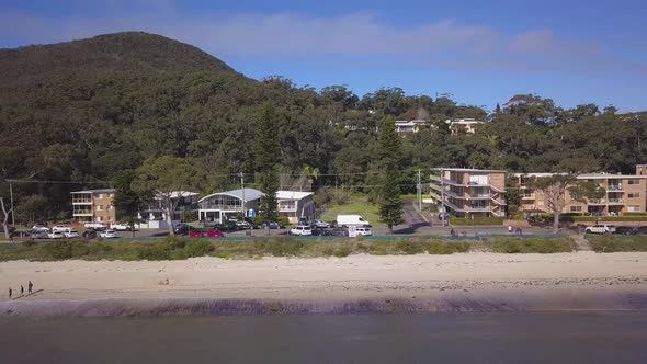Beautiful aerial pan over the coastal beach with waterfront community houses or properties in a smal