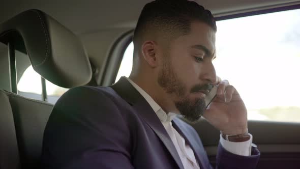 Focused Businessman Talking By Cell Phone in Car