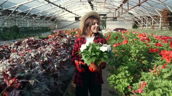 Girl in Straw Hat Going Through an Indoor Plant