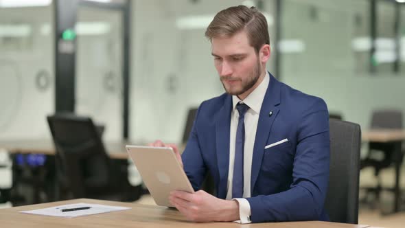 Young Businessman Using Tablet at Work