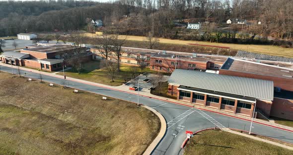 Wide angle view of American school campus. USA flag. Outdoor aerial of building and grounds. Educati