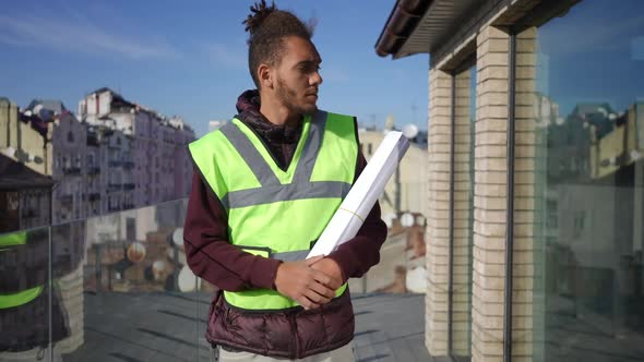 Portrait of African American Young Architect Standing on Building Terrace Looking Around and Looking