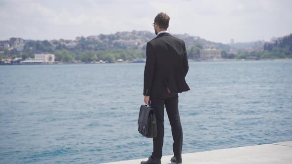 Businessman rejoicing against the ships in the city strait.