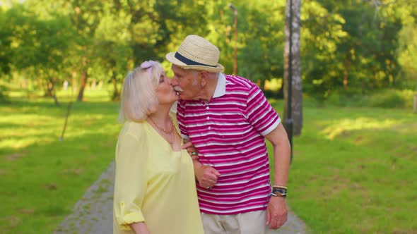 Senior Old Stylish Tourists Couple Grandmother Grandfather Having a Walk and Talking in Summer Park