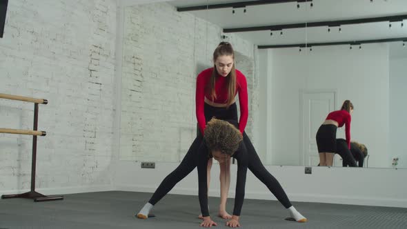 Personal Trainer Supporting Woman in Hamstring Muscles Stretch