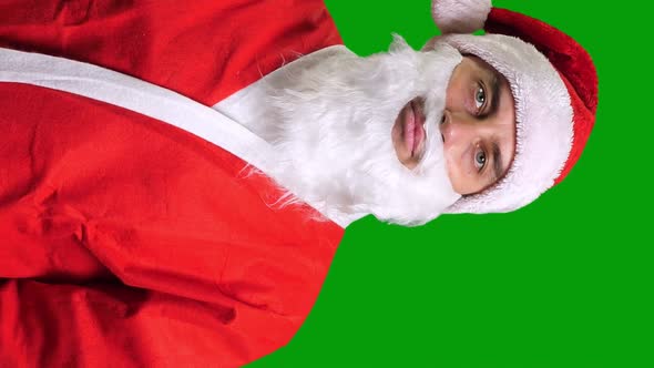 Santa Claus in Red Suit Pointing Up on Green Chroma Key Background