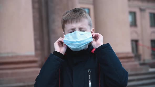 Child Boy Takes Off His Medical Mask Outdoors