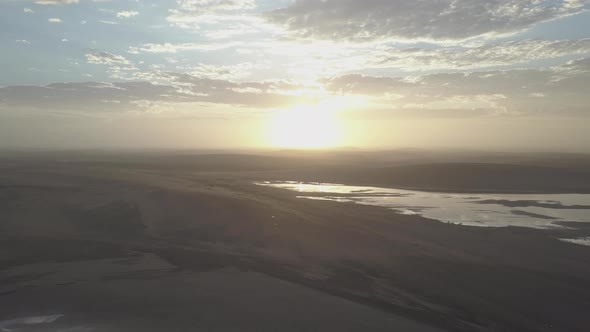 Aerial drone view of sunrise over a lake in Africa plains.