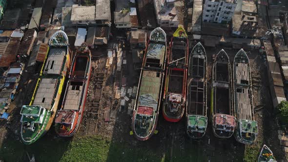 Aerial Over Row Of Disused Ships At Buriganga Riverbank In Bangladesh. Top Down, Dolly Right