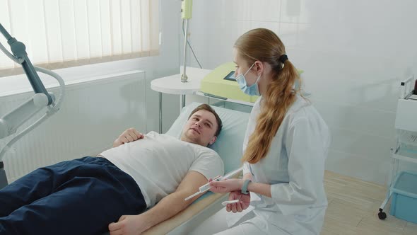 The Patient Communicates with a Young Nurse in the Clinic Ward