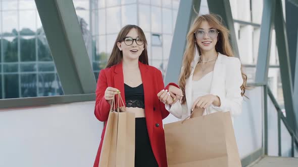 Happy young girls friends with shoping bags, talking and laughing. slow mo steadicam shot