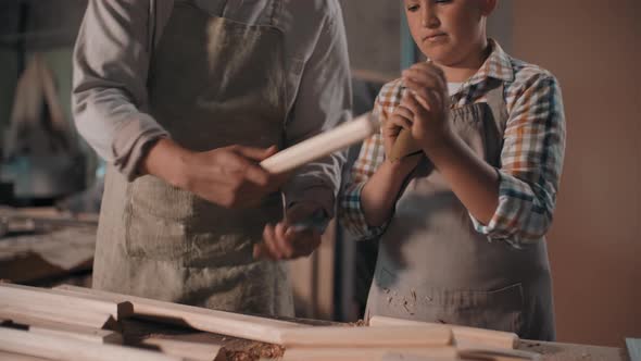 Boy Sanding Wood In Carpentry Workshop